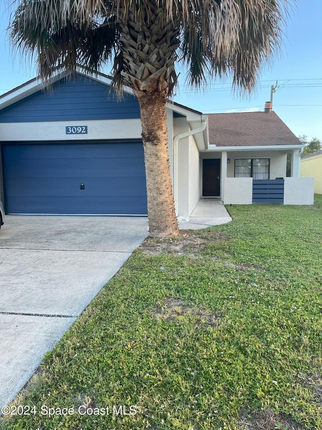 single story home featuring a front yard and a garage