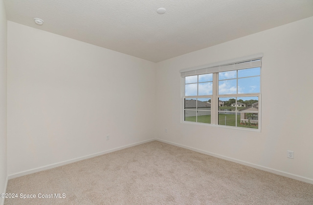 carpeted spare room with a textured ceiling