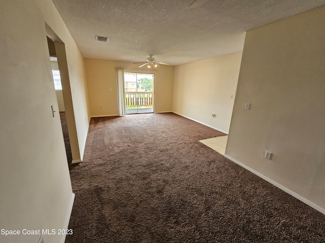 carpeted spare room featuring ceiling fan and a textured ceiling