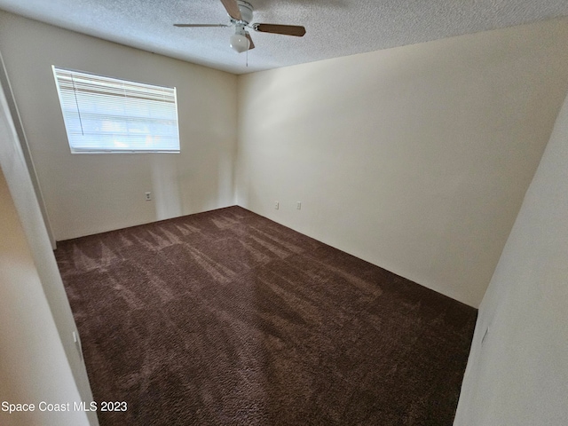 carpeted spare room featuring a textured ceiling and ceiling fan