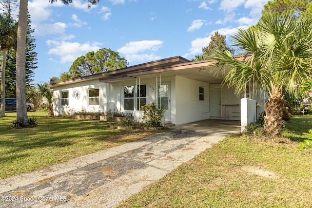 ranch-style home featuring a front lawn and a carport