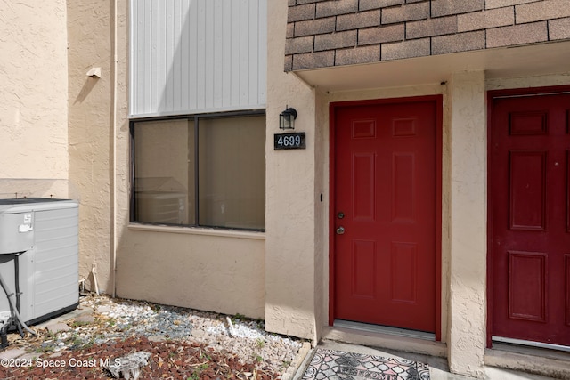 doorway to property featuring central air condition unit