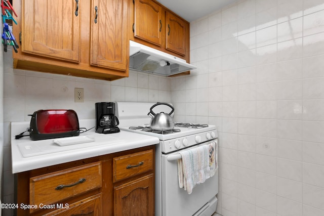 kitchen with tasteful backsplash and white gas range