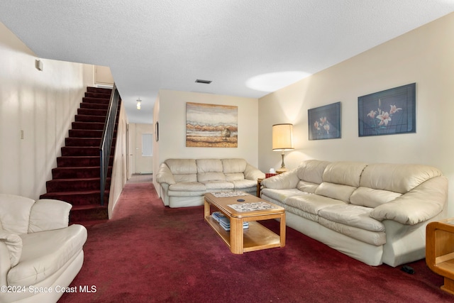 carpeted living room featuring a textured ceiling