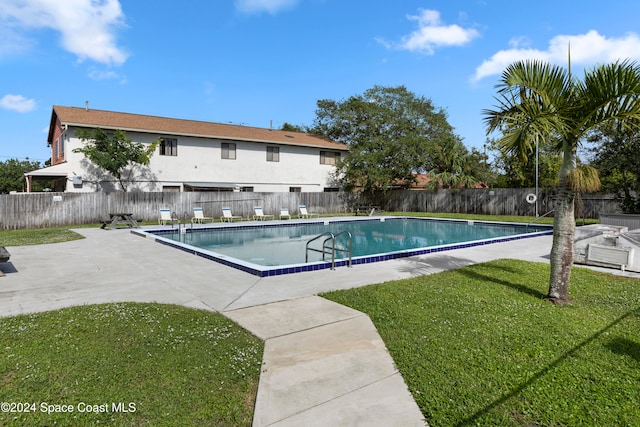 view of pool featuring a lawn and a patio