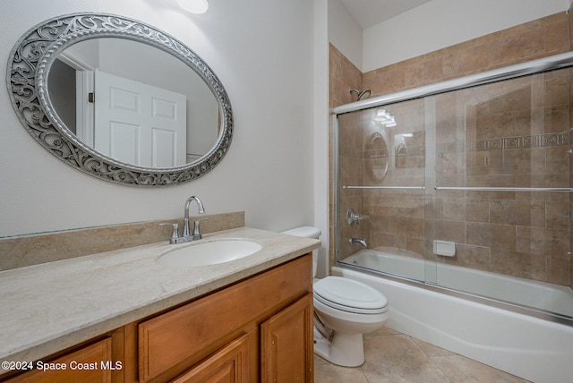 full bathroom with tile patterned floors, toilet, vanity, and combined bath / shower with glass door