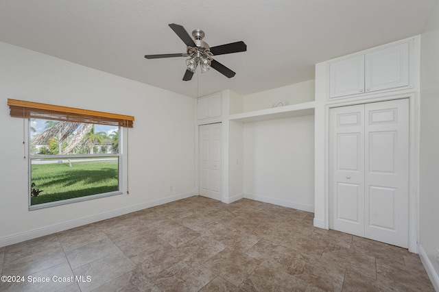 unfurnished bedroom featuring ceiling fan and a closet