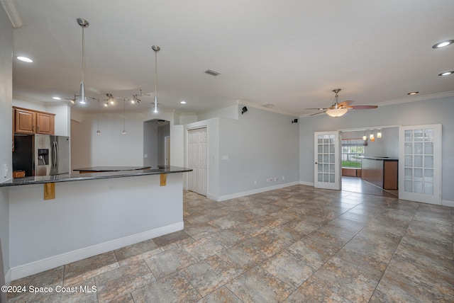 kitchen with ceiling fan, french doors, stainless steel fridge with ice dispenser, a kitchen bar, and ornamental molding