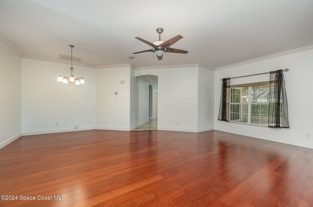 empty room featuring hardwood / wood-style flooring, ceiling fan with notable chandelier, and crown molding