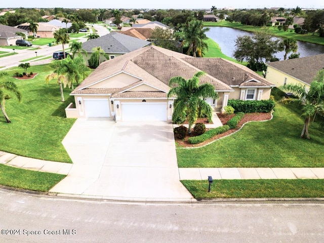 view of front of home featuring a water view, a garage, and a front lawn