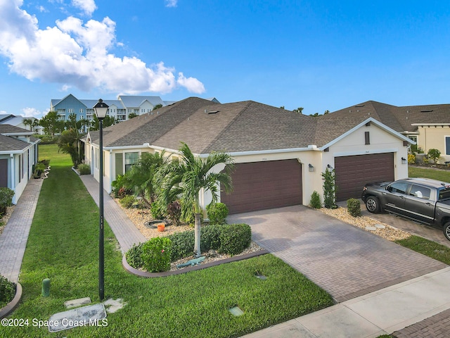 view of front of property featuring stucco siding, a front lawn, decorative driveway, and a garage