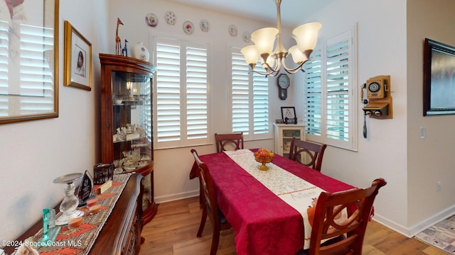 dining area featuring plenty of natural light, light hardwood / wood-style floors, and an inviting chandelier