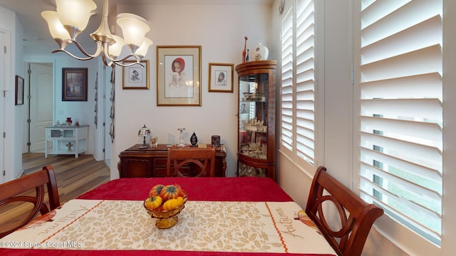 dining space featuring hardwood / wood-style floors, plenty of natural light, and an inviting chandelier