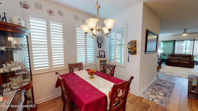 dining room featuring hardwood / wood-style floors and ceiling fan with notable chandelier