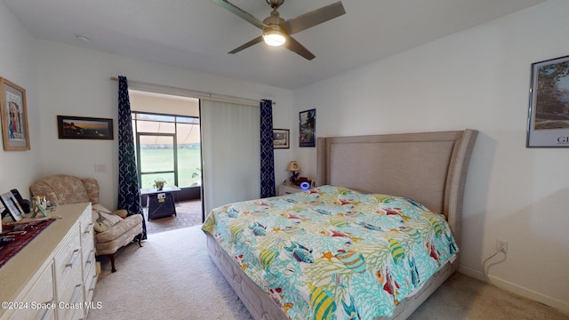 bedroom featuring ceiling fan, a water view, and light carpet