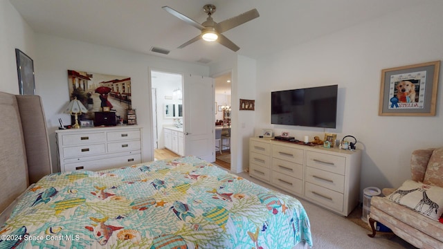 bedroom featuring ensuite bathroom, ceiling fan, and light colored carpet