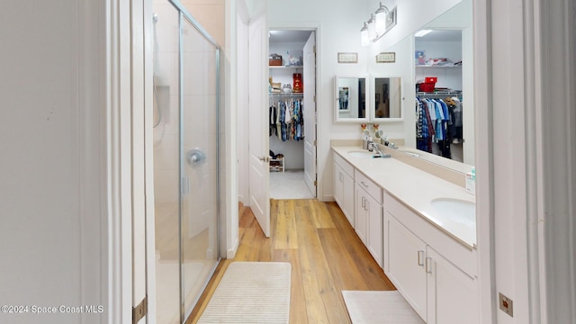 bathroom featuring hardwood / wood-style floors, vanity, and a shower with door