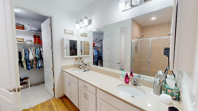 bathroom featuring walk in shower, vanity, and hardwood / wood-style flooring