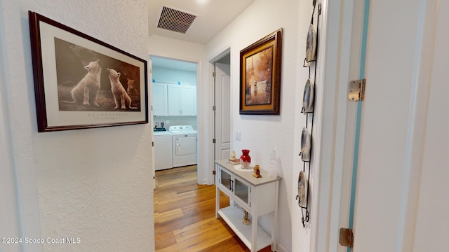 hallway featuring light wood-type flooring and independent washer and dryer