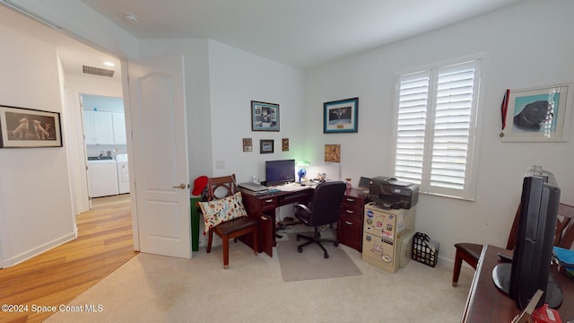 home office featuring washing machine and clothes dryer and light hardwood / wood-style flooring