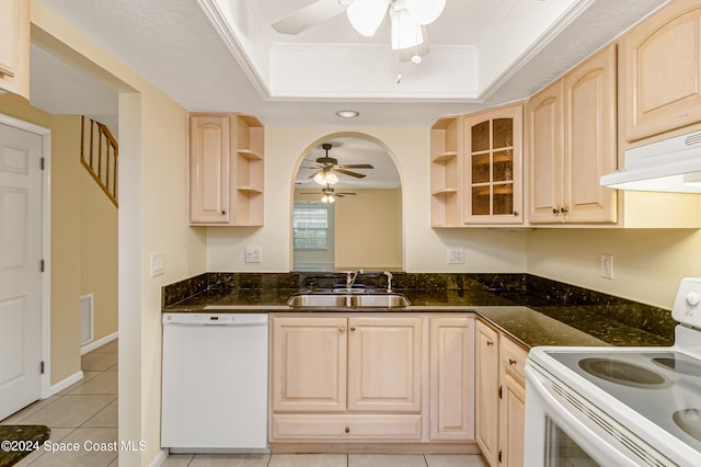 kitchen with light brown cabinets, white appliances, crown molding, sink, and a tray ceiling