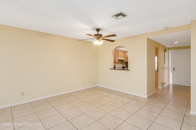 unfurnished room featuring ceiling fan, light tile patterned floors, and a textured ceiling