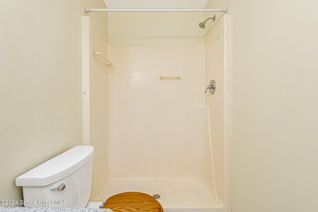 bathroom featuring toilet and walk in shower