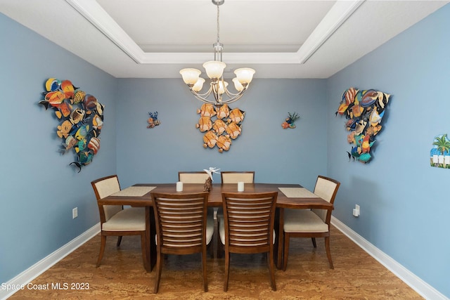 dining space featuring a tray ceiling, a chandelier, and wood-type flooring