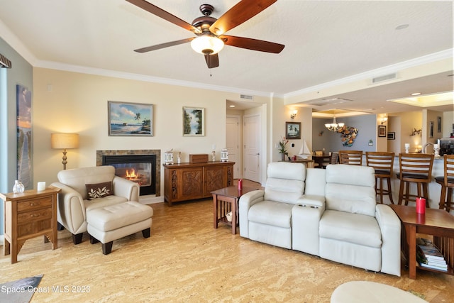 living room featuring ceiling fan with notable chandelier and ornamental molding