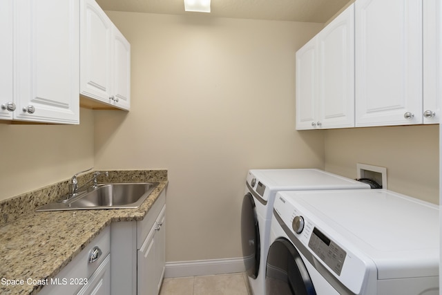 washroom featuring cabinets, light tile patterned floors, sink, and washing machine and dryer