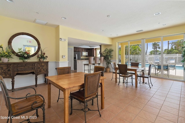 tiled dining area featuring a textured ceiling