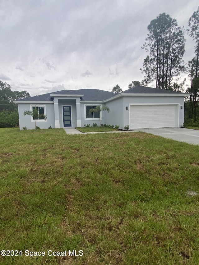 single story home with a garage and a front lawn