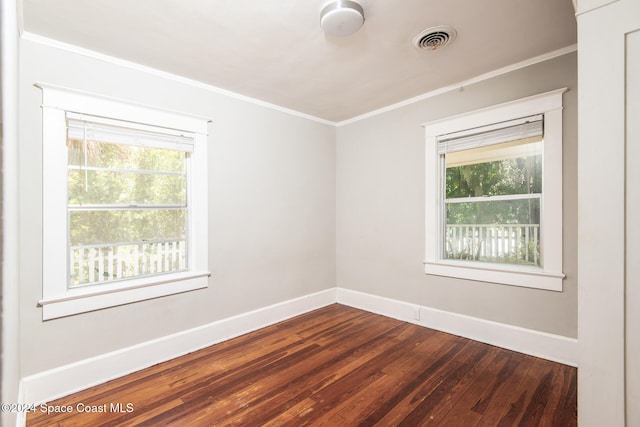 spare room with a wealth of natural light, wood-type flooring, and ornamental molding