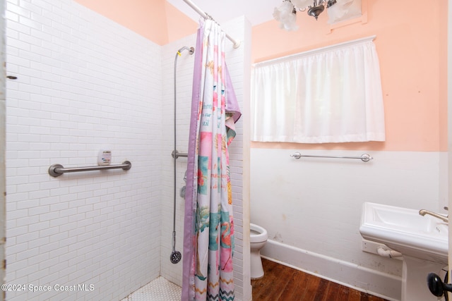 bathroom featuring toilet, wood-type flooring, and a shower with curtain