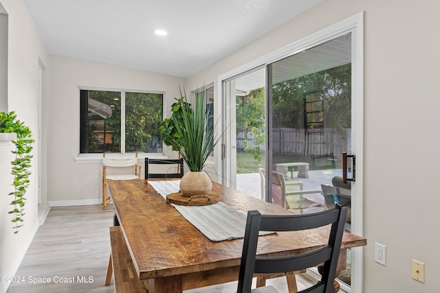 dining room featuring vaulted ceiling and light wood-type flooring