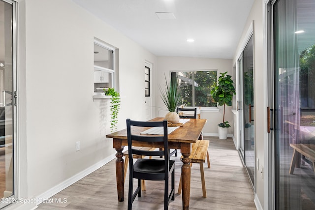 dining space with light hardwood / wood-style floors and lofted ceiling