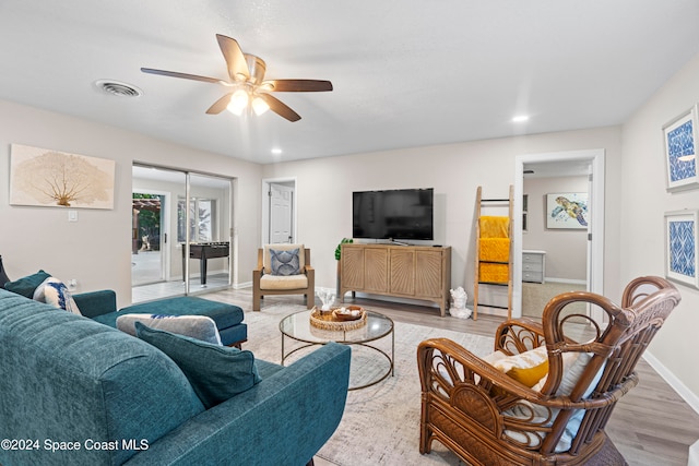 living room featuring light hardwood / wood-style flooring and ceiling fan