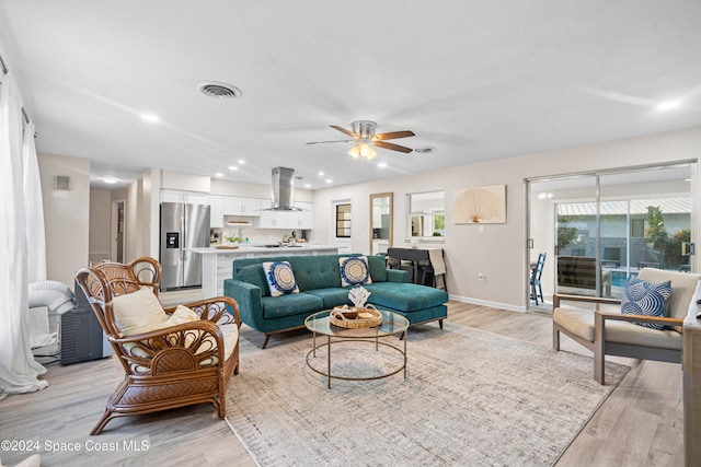 living room featuring ceiling fan and light hardwood / wood-style floors