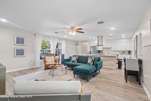 living room with ceiling fan and light wood-type flooring