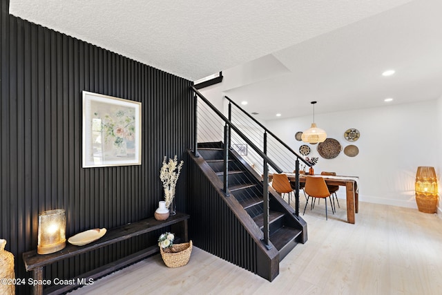 stairway featuring hardwood / wood-style floors and a textured ceiling