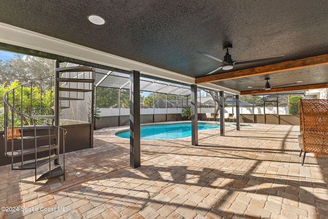 view of swimming pool featuring a lanai, a patio area, and ceiling fan