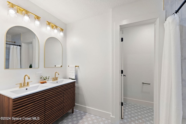 bathroom featuring a shower with curtain, vanity, and a textured ceiling