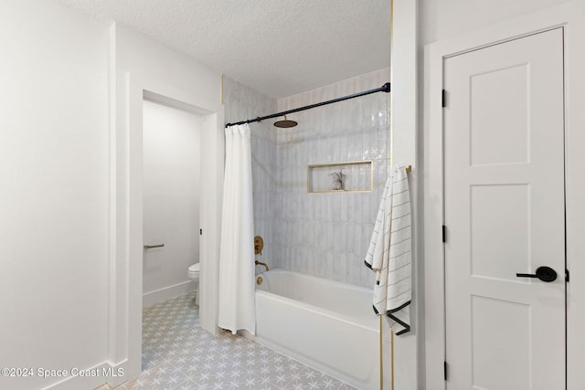 bathroom featuring shower / bath combination with curtain, a textured ceiling, and toilet