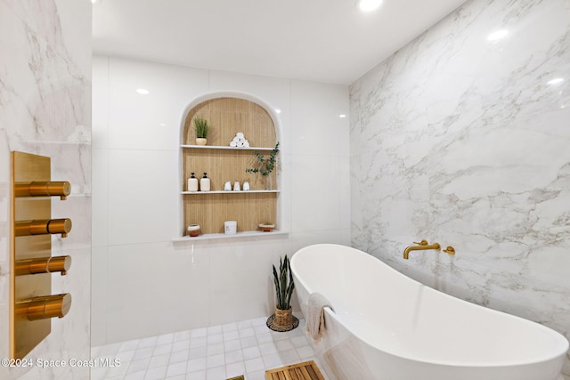 bathroom featuring a bath and tile walls