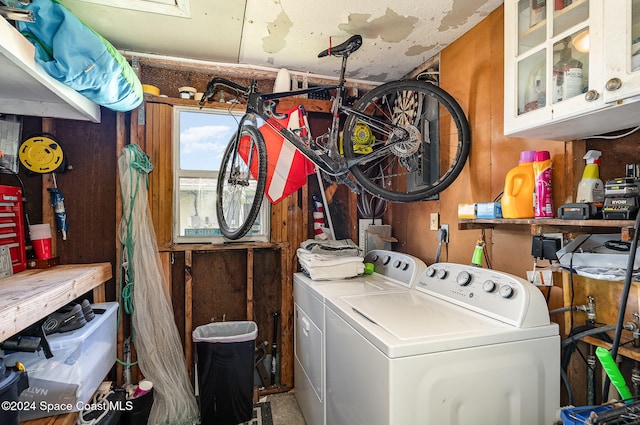 laundry room featuring separate washer and dryer, cabinets, and a workshop area