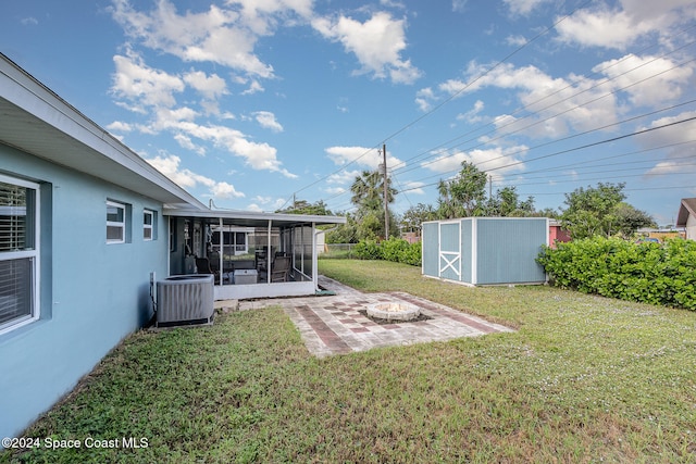 view of yard with a patio, a storage unit, central AC unit, and a sunroom