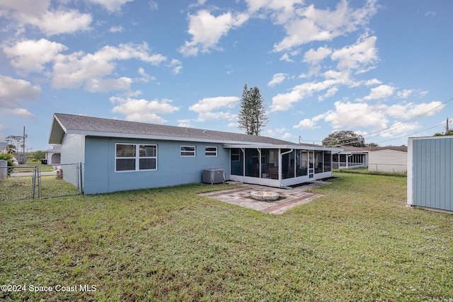 back of house with a sunroom, a patio area, a yard, and central AC