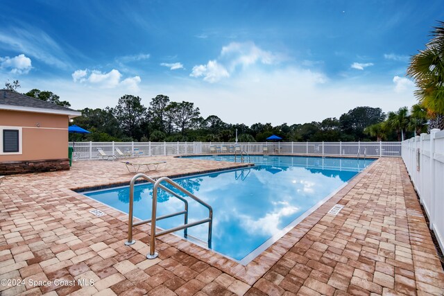 community pool featuring fence and a patio