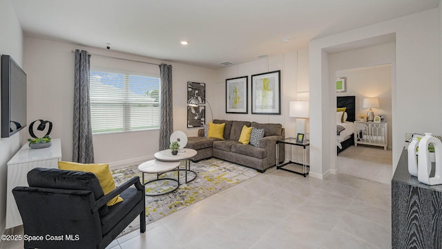 living room with light tile patterned flooring, visible vents, and baseboards