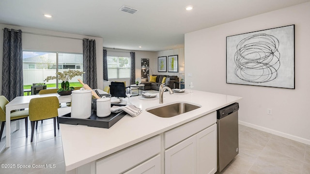 kitchen featuring visible vents, stainless steel dishwasher, open floor plan, white cabinetry, and a sink